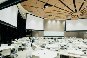 A hall with bright white lighting and screens