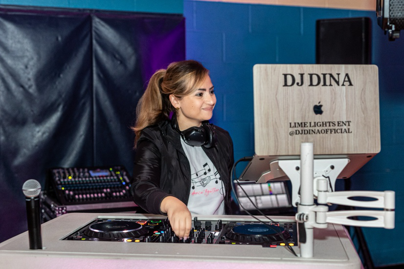 Wedding DJ performing beside a custom dance floor wrap at a reception