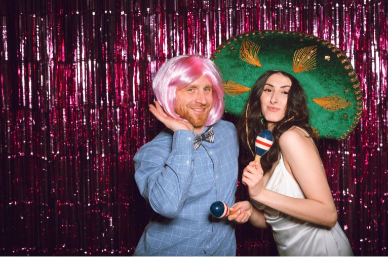 Guests using fun props in photo booth at Cleveland party or wedding event