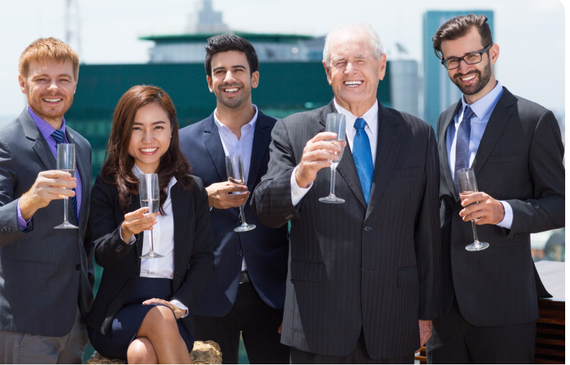 senior businessman with business professionals holding champagne glasses at corporate celebration event