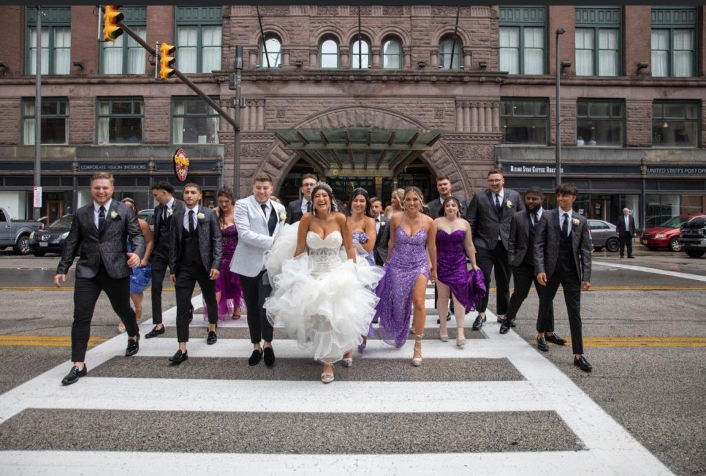 Bride, groom, bridesmaids, and groomsmen walking together outside during a Cleveland wedding reception celebration.