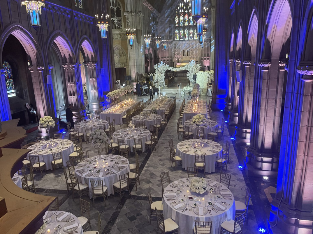 a large venue with fancy tables and chandeliers on the ceiling
