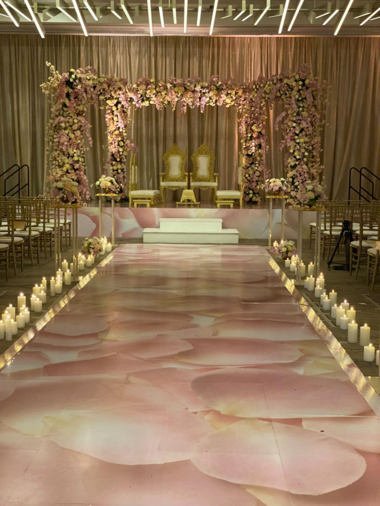 lights and candles surrounding the aisle at an event